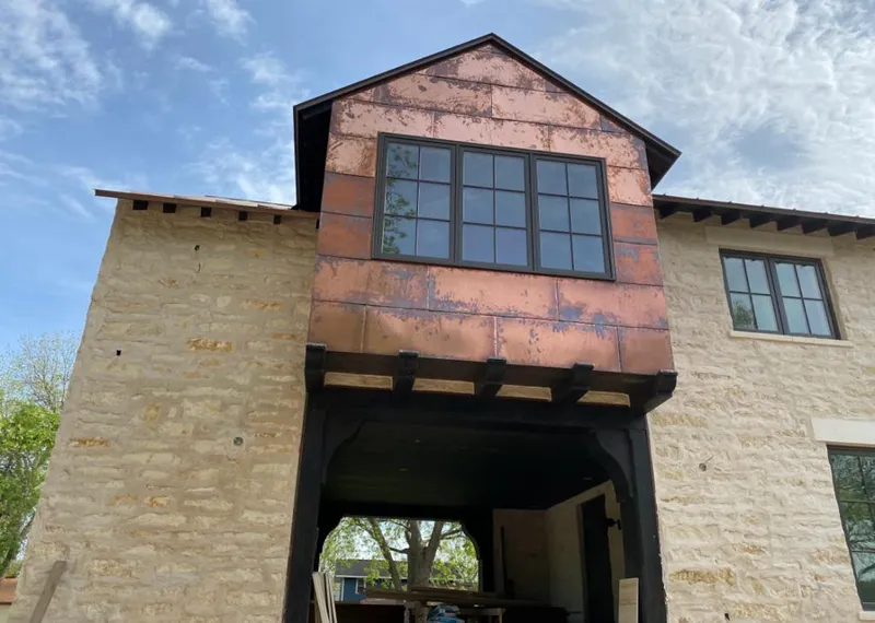 Copper metal panel facade on a stone building for Roof Repair in Lakewood
